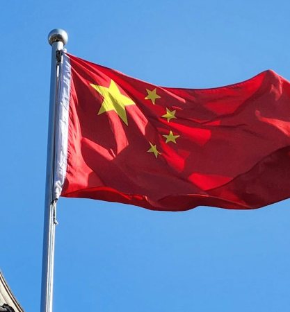 Foto da bandeira da China hasteada sobre telhado tradicional chinês